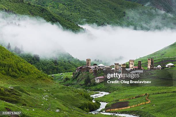 scenic mountain village ushguli, svaneti region of georgia. landscape with misty clouds and river stream - kaukasus geografische lage stock-fotos und bilder