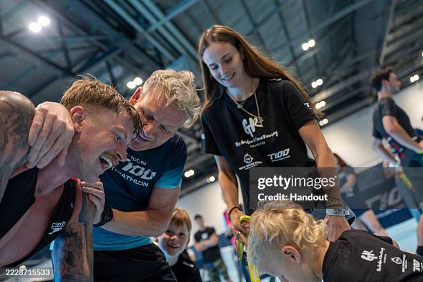 In this handout image provided by T100 Triathlon, swimmer Adam Peaty is congratulated by father-in-law to be Gordon Ramsay at the finish of the...