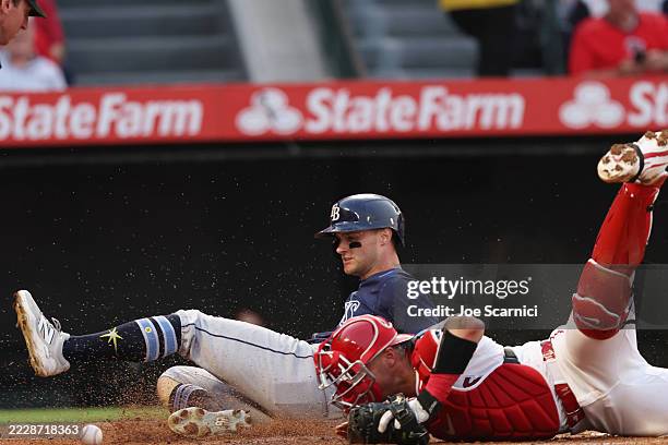 Jake Mangum of the Tampa Bay Rays scores on a sacrifice bunt against Logan O'Hoppe of the Los Angeles Angels in the fourth inning at Angel Stadium of...