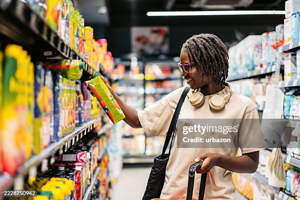 young black woman shopping for juice at the supermarket - juice box stock pictures, royalty-free photos & images