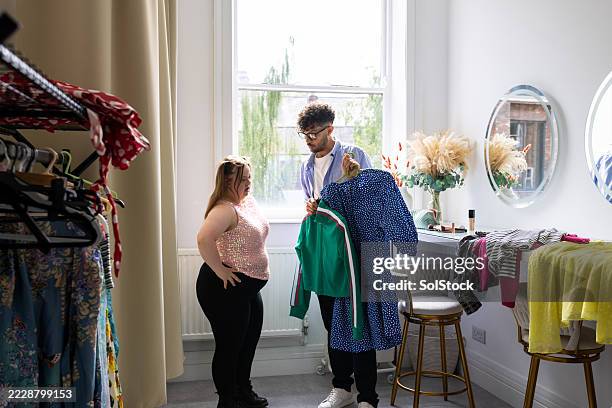 deciding which outfit to wear for a photoshoot - celebrity stylist stock pictures, royalty-free photos & images