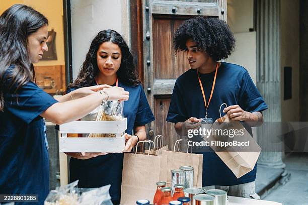 volunteers preparing grocery bags for donation - food insecurity stock pictures, royalty-free photos & images