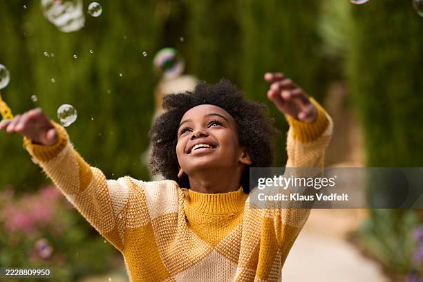 girl looking up while playing with bubbles - dreaming stock pictures, royalty-free photos & images