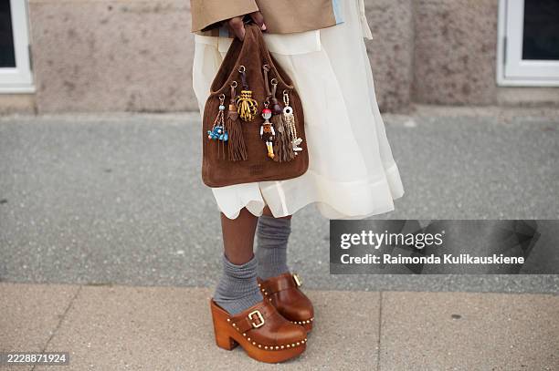 Zufi Alexander wears white sheer skirt, grey socks, brown mules, brown jacket and a brown suede bag with charms during Copenhagen Fashion Week day...