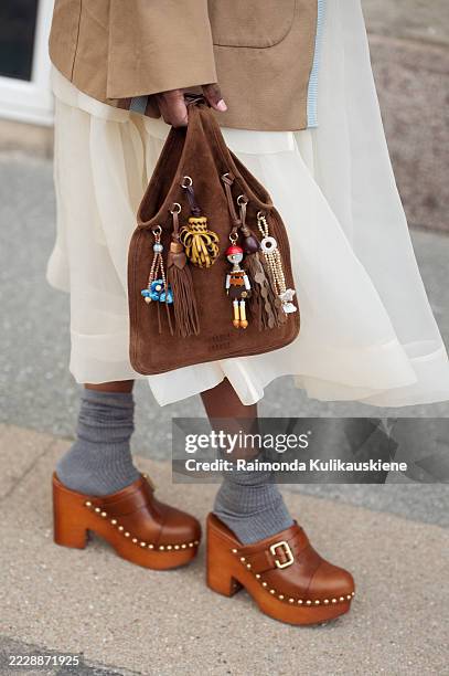 Zufi Alexander wears white sheer skirt, grey socks, brown mules, brown jacket and a brown suede bag with charms during Copenhagen Fashion Week day...
