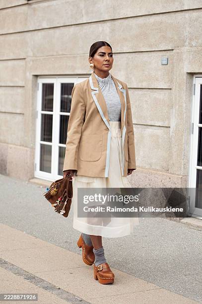 Zufi Alexander wears white sheer skirt, grey socks, brown mules, grey top, brown jacket and a brown suede bag with charms during Copenhagen Fashion...