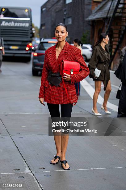 Guest wears red blazer, Celine bag, brown corset, cropped black pants capri pants, sandals outside Gestuz during Copenhagen Fashion Week day three on...