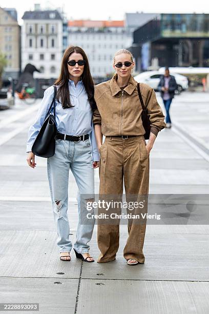 Annabel Rosendahl wears blue blouse, ripped denim jeans, black bag & Tine Andrea wears light brown zipper jacket, pants outside Gestuz during...