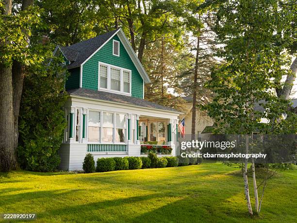 vista d'angolo della casa estiva verde e bianca sul lago michigan. - casa al mare foto e immagini stock