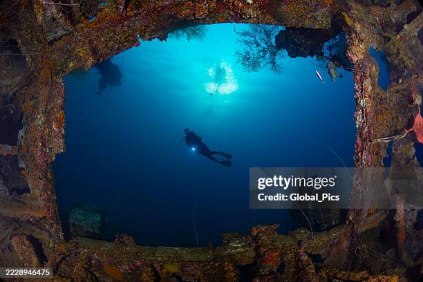 the shipwreck teshio maru and a diver - palau, micronesia - shipwreck stock pictures, royalty-free photos & images