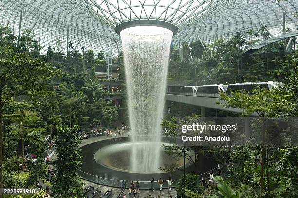 People visit the Rain Vortex, the world's tallest indoor waterfall at the Jewel complex at Changi Airport in Singapore, in July 11, 2025. The...