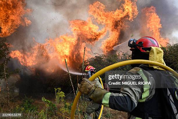 Firefighter falls on the ground while working to extinguish a wildfire in San Cibrao das Viñas, outside Ourense, northwestern Spain, on August 12,...