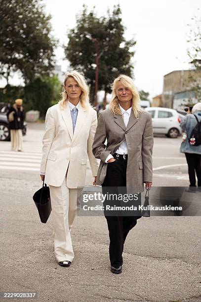 Guest wears white suit made of pants and a blazer and white shirt and blue tie anda a black bag and a guest wears black pants, white shirt and a...