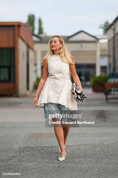 Guest wears long straight blonde hair worn loose with a subtle side part, pink lipstick and light eyeliner, small hoop earrings, a delicate pendant...