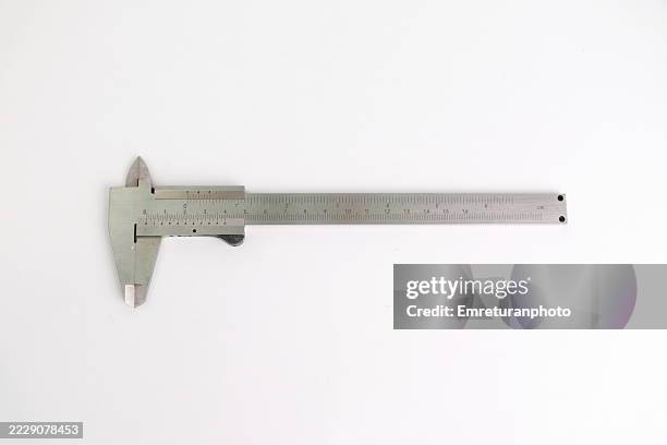 high angle view of a caliper against white background. - calibrador fotografías e imágenes de stock