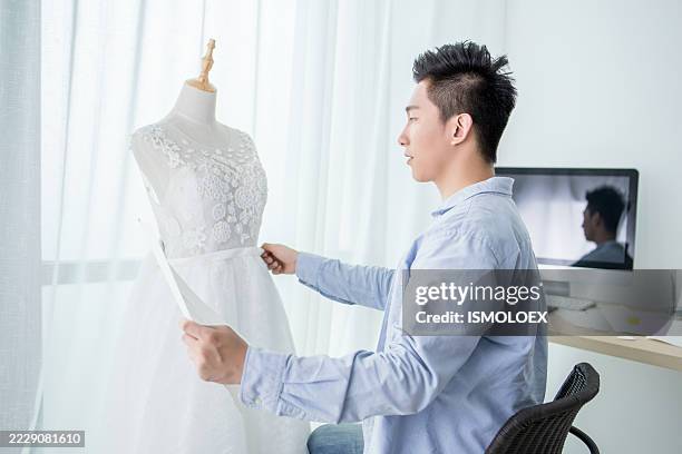 un hombre diseñando un vestido de novia en un maniquí - estudio de diseño de modas fotografías e imágenes de stock