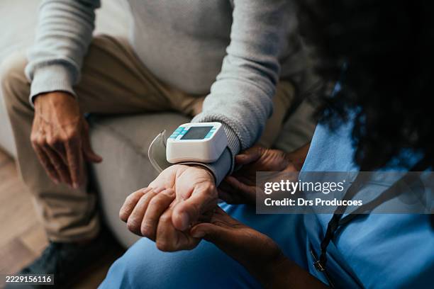 home medical consultation, elderly person measuring blood pressure - medische apparatuur stockfoto's en -beelden