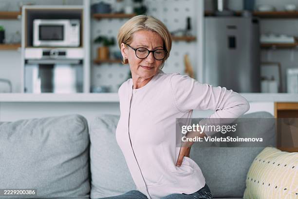 woman suffering from backache. - life stages stock pictures, royalty-free photos & images