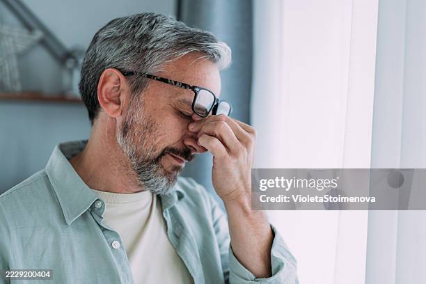 man suffering with a migraine. - com as mãos na cabeça imagens e fotografias de stock