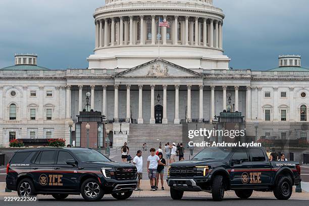 An Immigration and Customs Enforcement branded GMC SUV and an Immigration and Customs Enforcement branded Ford pickup truck are parked at the US...