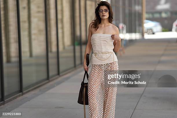 Lea Naumann, attending the Herskind show during Copenhagen Fashion Week SS26, is seen wearing a strapless ruched beige top with a fitted silhouette...