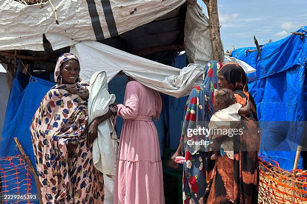 Sudanese relatives of cholera infected patients wait at the cholera isolation centre where their loves ones receive treatment, in at the refugee...