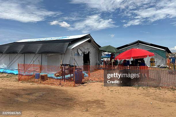 People sit outside the cholera isolation centre in at the refugee camps of western Sudan, in Tawila city in Darfur, on August 14, 2025. At least 40...
