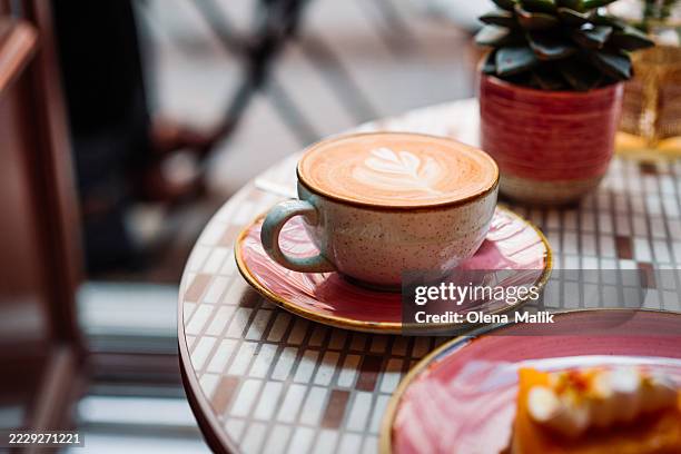 warm latte art coffee on table with cozy atmosphere - pumpkin latte stock pictures, royalty-free photos & images