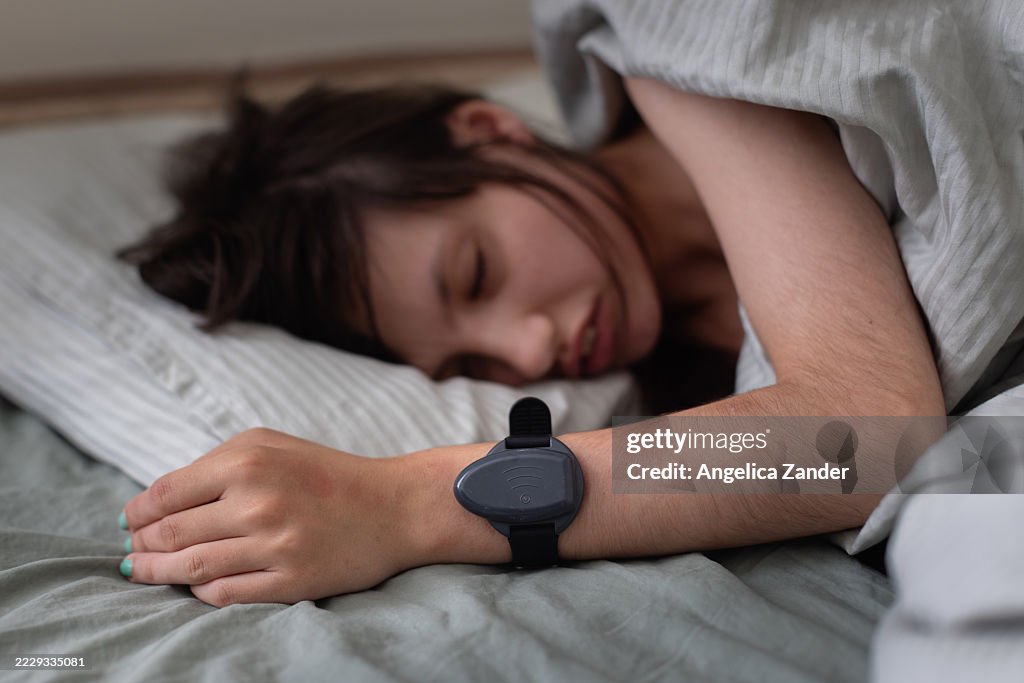 Teenager Sleeping Peacefully with a Seizure Alarm Around wrist for Epilepsy Management
