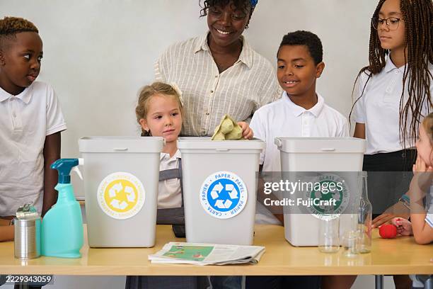 des élèves du primaire apprennent le recyclage avec leur enseignant - corbeille à papier photos et images de collection
