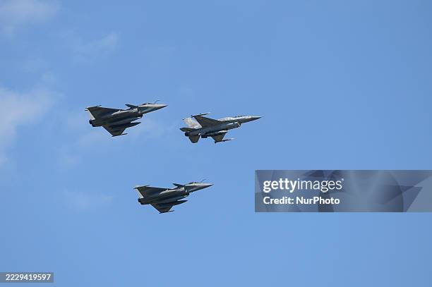Polish air force F-16 is flanked on either side by Dassault Rafale fighter jets as they perform a flyover during the National Army Day military...