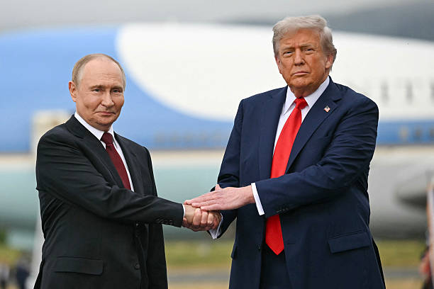 President Donald Trump greets Russian President Vladimir Putin on the tarmac after they arrived at Joint Base Elmendorf-Richardson in Anchorage,...