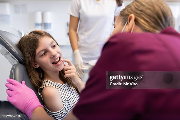 zahnarzt in der praxis bei der arbeit mit kind - zahnkaries stock-fotos und bilder