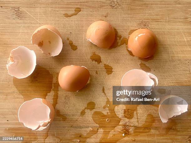opened eggs shells on wooden cutting board - eggshell stock pictures, royalty-free photos & images