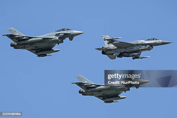 Polish Air Force General Dynamics F-16CJ Fighting Falcon, accompanied by two German Air Force Eurofighter EF-2000 Typhoon jets, soars over Warsaw...