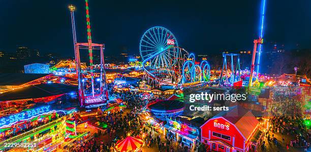 aerial view of winter wonderland christmas market and amusement park at night in hyde park, london, uk - winter wonderland londen stockfoto's en -beelden