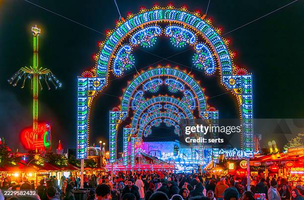 vibrant winter wonderland entrance arch with crowds at hyde park, london - winter wonderland londen stockfoto's en -beelden