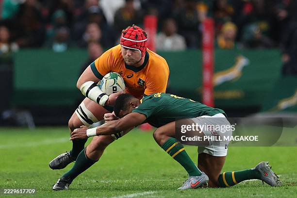 Australia's number eight Harry Wilson is tackled by South Africa's scrum-half Grant Williams during the Rugby Championship first round Test match...