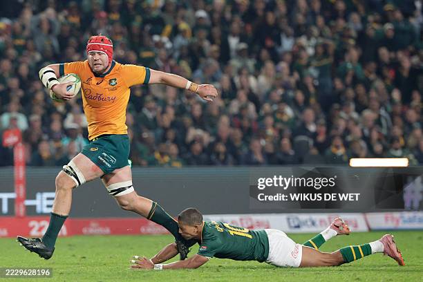Australia's number eight Harry Wilson runs with the ball to score a try as South Africa's fly-half Manie Libbok misses a tackle during the Rugby...