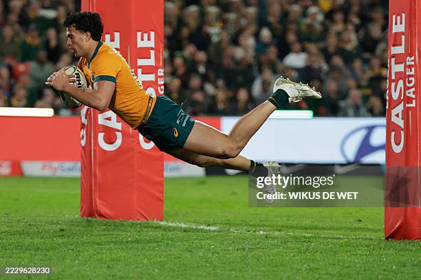 Australia's centre Joseph Aukuso-Suaalii dives across the line to score a try during the Rugby Championship first round Test match between South...