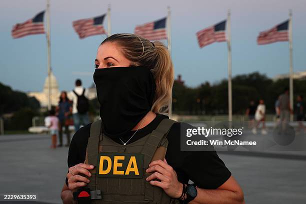 Drug Enforcement Administration agent stops to talk with tourists as they patrol near the Washington Monument on the National Mall on August 11, 2025...