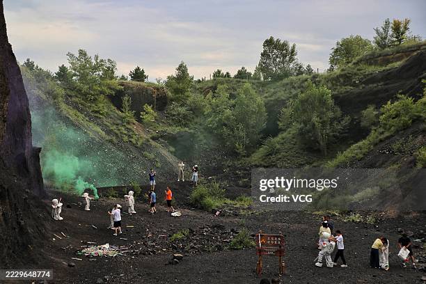Tourists in "spacesuits" pose for a photo while visiting Datong Volcano Cluster National Geological Park during summer vacation on August 10, 2025 in...