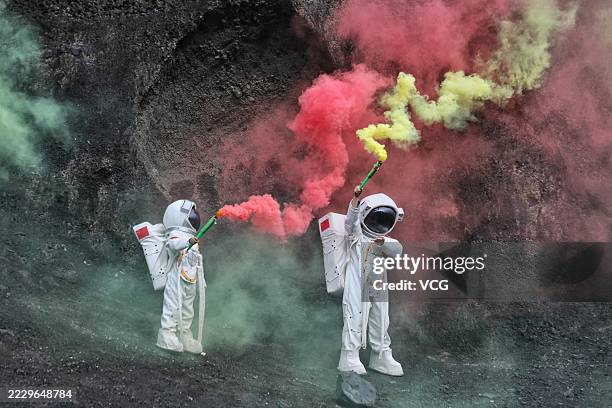Tourists in "spacesuits" pose for a photo while visiting Datong Volcano Cluster National Geological Park during summer vacation on August 10, 2025 in...