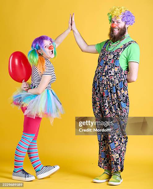 clowns couple giving high five each other - clown smile stock pictures, royalty-free photos & images