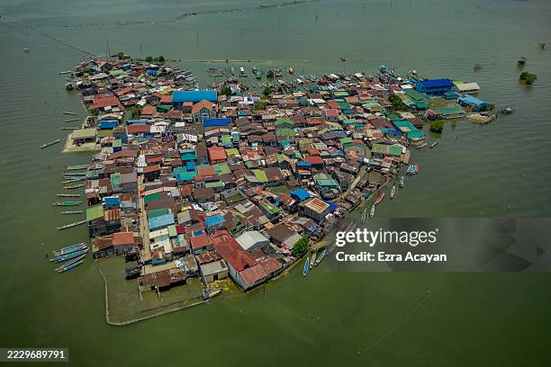 An aerial view taken with a drone shows Pugad Island, partly submerged in seawater amid rising tides on August 11, 2025 in Hagonoy, Philippines. In...