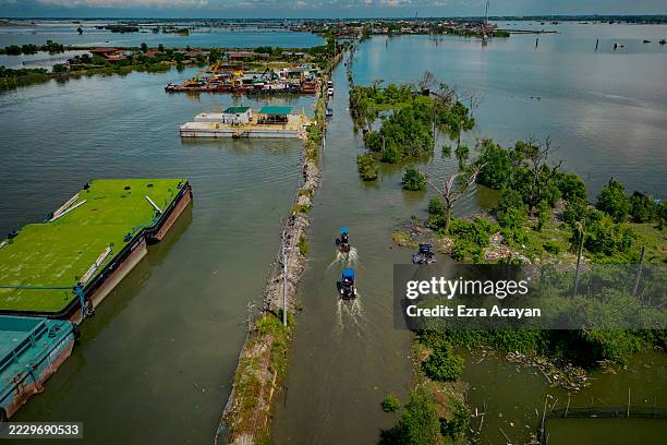 An aerial view taken with a drone shows a main highway flooded with seawater amid rising tides on August 8, 2025 in Bulakan, Philippines. In the...
