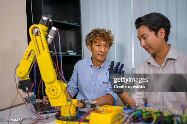 trabajo de ingeniería con brazo robótico en el taller. - inventor fotografías e imágenes de stock