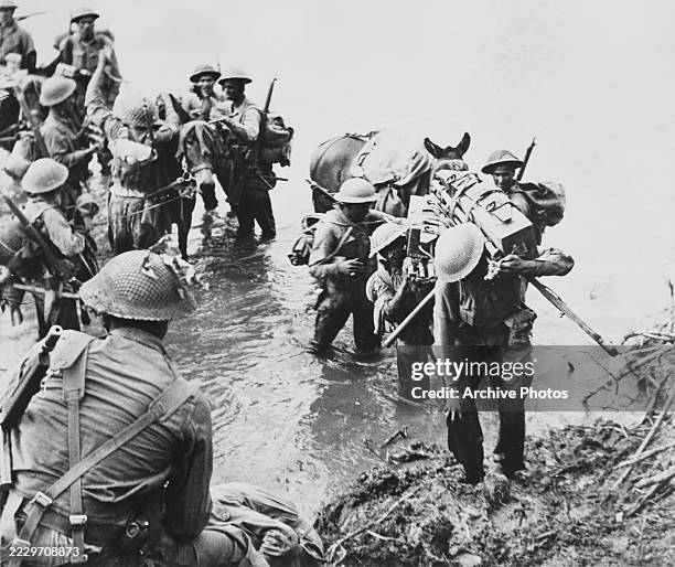 Indian troops of the 26th Indian Brigade, 36th Indian Infantry Division of the British 14th Army unloading ammunition boxes and supplies from pack...
