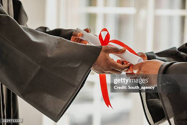 i laureati celebrano i risultati conseguiti con i diplomi in una gioiosa cerimonia nel campus universitario - laurea foto e immagini stock
