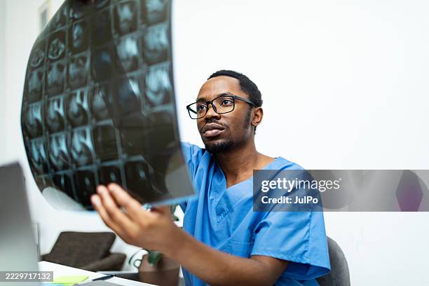 doctor examining x-ray image at office - radiology technician stock pictures, royalty-free photos & images